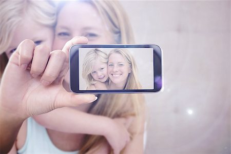 simsearch:400-07664794,k - Hand holding smartphone showing against cute little girl and mother on bed Stock Photo - Budget Royalty-Free & Subscription, Code: 400-08076826