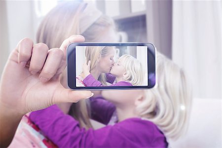 simsearch:400-07664794,k - Hand holding smartphone showing against happy mother and daughter on the couch Stock Photo - Budget Royalty-Free & Subscription, Code: 400-08076828