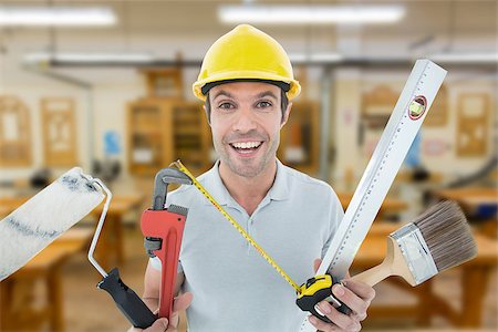 simsearch:400-08077074,k - Portrait of happy worker holding various equipment against workshop Foto de stock - Super Valor sin royalties y Suscripción, Código: 400-08077078