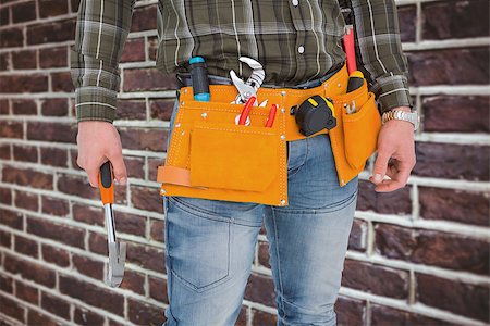 simsearch:400-08077176,k - Manual worker holding hammer against red brick wall Foto de stock - Super Valor sin royalties y Suscripción, Código: 400-08077149