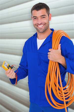 simsearch:400-08077176,k - Smiling electrician with wire roll and multimeter against grey shutters Foto de stock - Super Valor sin royalties y Suscripción, Código: 400-08077171