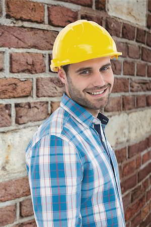 simsearch:400-08077176,k - Confident repairman wearing hard hat against red brick wall Foto de stock - Super Valor sin royalties y Suscripción, Código: 400-08077182
