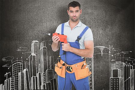 Confident male carpenter in overall holding drill machine against hand drawn city plan Stock Photo - Budget Royalty-Free & Subscription, Code: 400-08077302