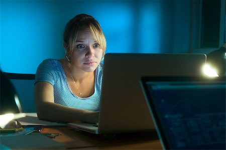 facebook - Beautiful woman working late at night in office, surfing the web and reading a post on social network with laptop computer. The girl looks at the screen with scared expression Foto de stock - Super Valor sin royalties y Suscripción, Código: 400-08077582