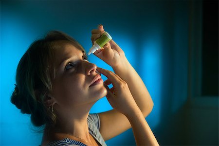 eye drops with eye dropper - Beautiful young latina woman with eyesight problems, working late at night in office. The girl puts collyrium drops in tired eyes and smiles. Stock Photo - Budget Royalty-Free & Subscription, Code: 400-08077583