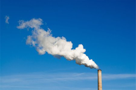 Industrial smokestack spewing white polluting smoke cloud horizontally from right to left into clear blue sky. Fotografie stock - Microstock e Abbonamento, Codice: 400-08077815