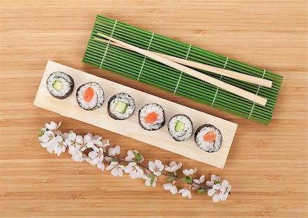 Sushi maki set with fresh sakura branch over bamboo table Stock Photo - Budget Royalty-Free & Subscription, Code: 400-08078045