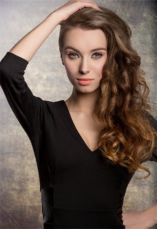 simsearch:400-06790945,k - fashion brunette female posing with cute black dress, stylish make-up and long shiny wavy hair. Charming expression looking in camera Photographie de stock - Aubaine LD & Abonnement, Code: 400-08078174