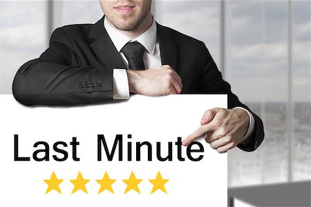 businessman in black suit pointing on sign last minute rating stars Stock Photo - Budget Royalty-Free & Subscription, Code: 400-08070191