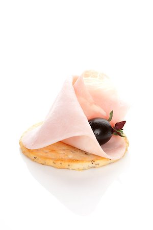 Delicious canape with ham, black olive and fresh rosemary herb isolated on white background. Culinary eating. Foto de stock - Super Valor sin royalties y Suscripción, Código: 400-08070586