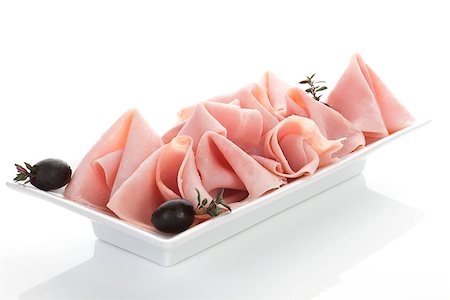 simsearch:400-08070549,k - Delicious ham slices with thyme and black olives on white tray on white background. Culinary meat concept. Stockbilder - Microstock & Abonnement, Bildnummer: 400-08070590