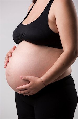 simsearch:400-04859723,k - Pregnant woman showing her belly, over a gray background Fotografie stock - Microstock e Abbonamento, Codice: 400-08070627