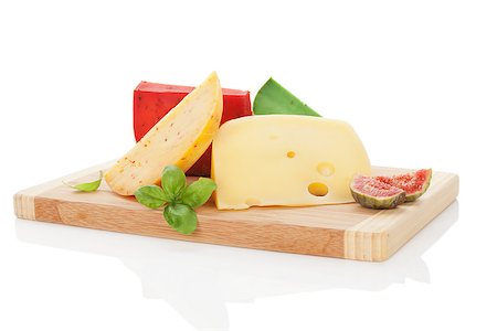 Colorful luxurious cheese variation with fresh basil and fig on cutting board isolated on white background. Culinary cheese still life. Photographie de stock - Aubaine LD & Abonnement, Code: 400-08071174