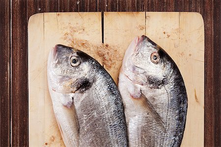 simsearch:400-07776969,k - Two fresh sea bream detail on wooden cutting board, natural brown color concept. Traditional mediterranean seafood eating. Foto de stock - Super Valor sin royalties y Suscripción, Código: 400-08071194