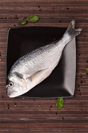 simsearch:400-07776969,k - Fresh gilt head bream on black square plate with colorful peppercorn and fresh basil leaves on brown natural background. Culinary seafood concept. Foto de stock - Super Valor sin royalties y Suscripción, Código: 400-08071196