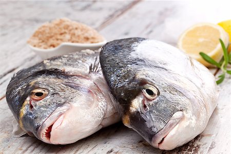 simsearch:400-07776969,k - Two fresh raw sea bream fish on white wooden textured background with lemon, herbs and sea salt. Luxurious marine mediterranean concept. Foto de stock - Super Valor sin royalties y Suscripción, Código: 400-08071191