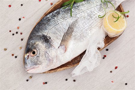 simsearch:400-07776969,k - Fresh gilt head bream on wooden spoon with colorful peppercorns and fresh herbs on white background. Culinary seafood eating, mediterranean style. Foto de stock - Super Valor sin royalties y Suscripción, Código: 400-08071193