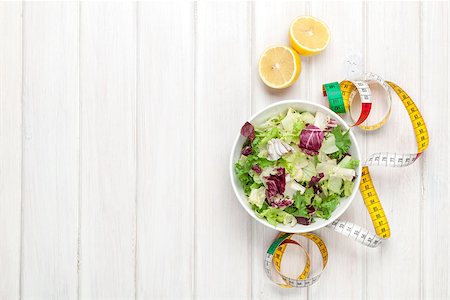simsearch:400-06485512,k - Fresh healthy salad, utensils and tape measure over white wooden table. View from above with copy space Stock Photo - Budget Royalty-Free & Subscription, Code: 400-08071508