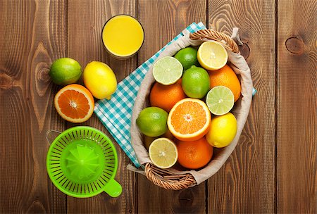 Citrus fruits and glass of juice. Oranges, limes and lemons. Top view over wood table background Stock Photo - Budget Royalty-Free & Subscription, Code: 400-08071537