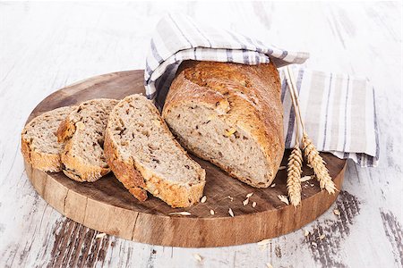 simsearch:400-07996450,k - Delicious dark bread slices on wooden kitchen board on wooden background. Healthy bread eating, rustic styles. Foto de stock - Royalty-Free Super Valor e Assinatura, Número: 400-08072031