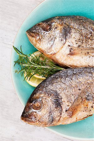 simsearch:400-07776969,k - Two grilled fish head on plate close up, top view. Culinary grilled seafood eating. Healthy mediterranean cuisine. Foto de stock - Super Valor sin royalties y Suscripción, Código: 400-08072042