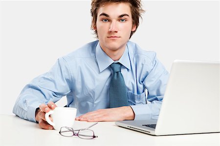 Exhausted young man in the office with the laptop on his front Foto de stock - Super Valor sin royalties y Suscripción, Código: 400-08072520