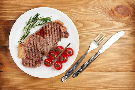 steak knife - Sirloin steak with rosemary and cherry tomatoes on a plate. View from above Stock Photo - Budget Royalty-Free & Subscription, Code: 400-08072737