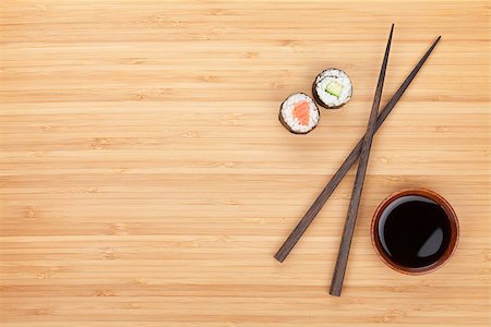 simsearch:400-08072780,k - Maki sushi, chopsticks and soy sauce on bamboo wooden table background with copy space Photographie de stock - Aubaine LD & Abonnement, Code: 400-08072786