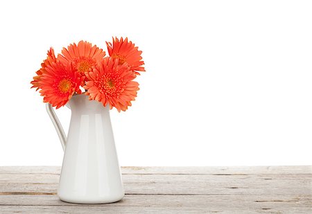 simsearch:400-07179442,k - Orange gerbera flowers in pitcher on wooden table. Isolated on white background Stock Photo - Budget Royalty-Free & Subscription, Code: 400-08072947