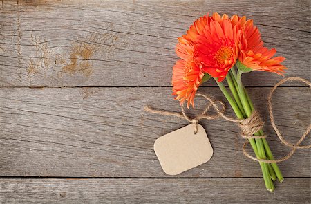 simsearch:400-07662543,k - Orange gerbera flowers with tag on wooden table Stock Photo - Budget Royalty-Free & Subscription, Code: 400-08072948