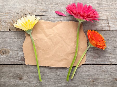 simsearch:400-07662543,k - Three colorful gerbera flowers with paper for copy space on wooden table Stock Photo - Budget Royalty-Free & Subscription, Code: 400-08072941
