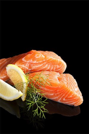 simsearch:400-08070549,k - Luxurious salmon background. Raw salmon piece with lemon and fresh dill isolated on black background. Culinary seafood eating. Stockbilder - Microstock & Abonnement, Bildnummer: 400-08073376