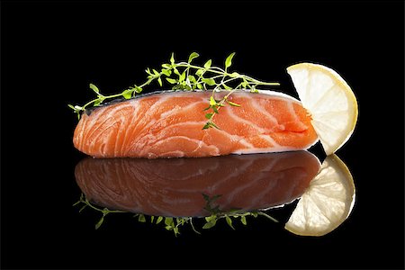 simsearch:400-08070549,k - Raw salmon steak with lemon and fresh herbs isolated on black with reflection. Healthy seafood eating. Stockbilder - Microstock & Abonnement, Bildnummer: 400-08073381