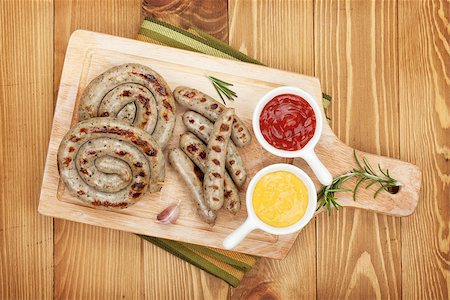 Grilled sausages with ketchup and mustard. Over wooden table background Stock Photo - Budget Royalty-Free & Subscription, Code: 400-08073801