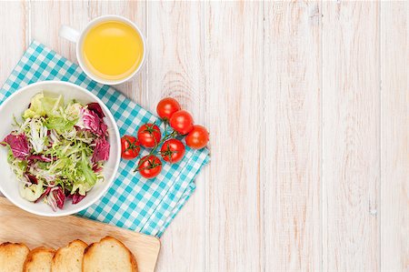 Healthy breakfast with salad, tomatoes and toasts on white wooden table. Top view with copy space Stock Photo - Budget Royalty-Free & Subscription, Code: 400-08073879