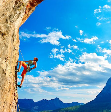 female rock climber climbs on a rocky wall Fotografie stock - Microstock e Abbonamento, Codice: 400-08094380