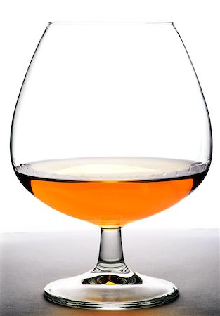 Glass with cognac on white background and wood base. Front view with copyspace. Close up shot. High resolution Stock Photo - Budget Royalty-Free & Subscription, Code: 400-08095287