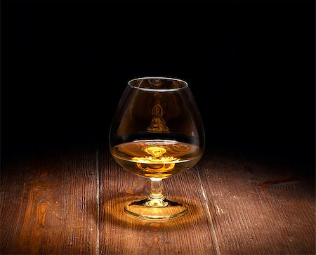Luxury still life with glass of cognac, on a wood background. Front view with copyspace. Close up shot. Photographie de stock - Aubaine LD & Abonnement, Code: 400-08095699