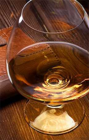 Luxury still life with glass of cognac and leather wallet on a wood background. Top view Stock Photo - Budget Royalty-Free & Subscription, Code: 400-08095704