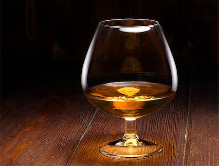 Luxury still life with glass of cognac, on a wood background. Front view with copyspace. Close up shot Stock Photo - Budget Royalty-Free & Subscription, Code: 400-08095702