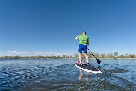simsearch:400-07795226,k - senior male on SUP (stand up paddleboard) on a lake under Colorado blue sky Foto de stock - Royalty-Free Super Valor e Assinatura, Número: 400-08097108