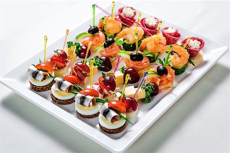 simsearch:400-07572419,k - Plate with various seafood and meat canapes. Pickled herring with egg, cheese and cherry,  salmon, prawns with cucumber and stuffed salami Stock Photo - Budget Royalty-Free & Subscription, Code: 400-08098500