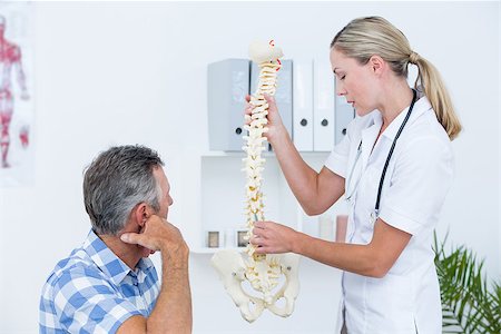 simsearch:400-04905111,k - Doctor showing her patient a spine model in medical office Stock Photo - Budget Royalty-Free & Subscription, Code: 400-08098763