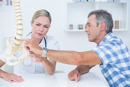 simsearch:400-04905106,k - Doctor showing her patient a spine model in medical office Stock Photo - Budget Royalty-Free & Subscription, Code: 400-08098770