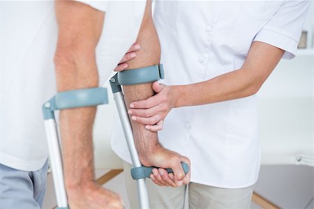 Doctor helping her patient walking with crutch in medical office Stock Photo - Budget Royalty-Free & Subscription, Code: 400-08098789