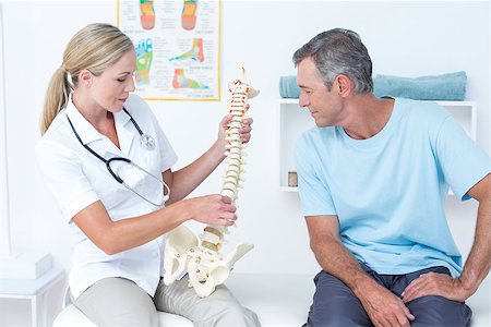 simsearch:400-08018430,k - Doctor showing her patient a spine model in medical office Photographie de stock - Aubaine LD & Abonnement, Code: 400-08098834