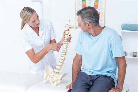 simsearch:400-08018430,k - Doctor showing her patient a spine model in medical office Photographie de stock - Aubaine LD & Abonnement, Code: 400-08098833