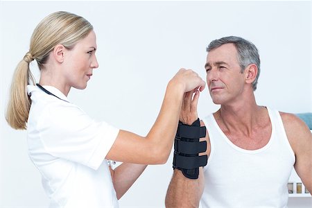 Doctor examining a man wrist in medical office Stock Photo - Budget Royalty-Free & Subscription, Code: 400-08098859