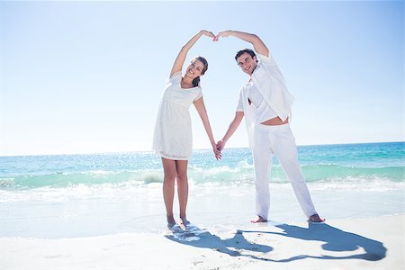 Happy couple forming heart shape with their hands at the beach Foto de stock - Super Valor sin royalties y Suscripción, Código: 400-08099309