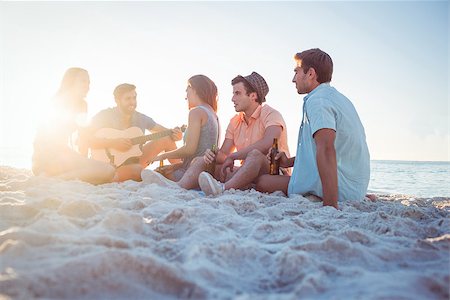 Happy hipsters relaxing and playing guitar at the beach Photographie de stock - Aubaine LD & Abonnement, Code: 400-08099474